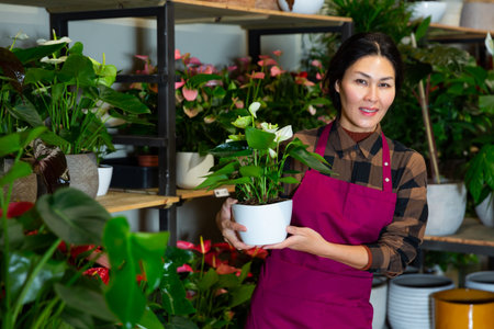 Portrait of an asian florist woman standing in a shop with flowersの写真素材