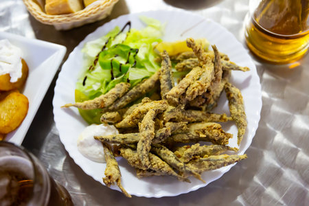 Fried anchovies with sauce and herbs.の写真素材