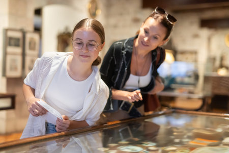 Woman and teenage girl looking at exhibit in museum display