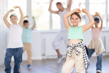 In sports studio, childrens team learns hip-hop dance accompanied by experienced man teacherの写真素材
