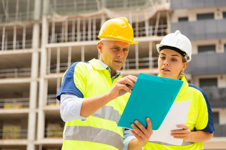 Two builders planning their work in construction plant