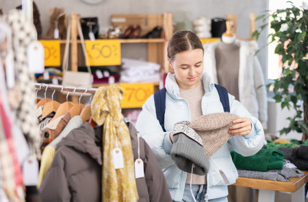 Teenage girl choosing a hat in the storeの写真素材