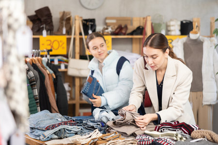 Adult woman and teenage girl choose trousersの写真素材