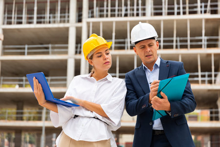 Two architects with laptop discussing construction plan