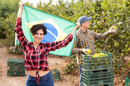 Girl waving Brazil flag during lemons harvest