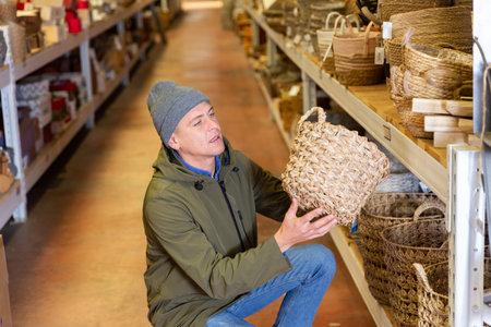 Portrait of man searching wicker basket for storageの写真素材