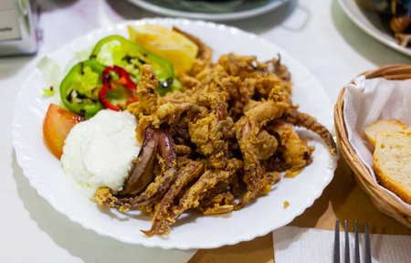 Popular Spanish tapa rejos - fried spicy tentacles of squid served with lemon sliceの写真素材