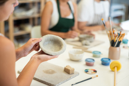 Close up girl forms bowl of clay during master class, top viewの写真素材