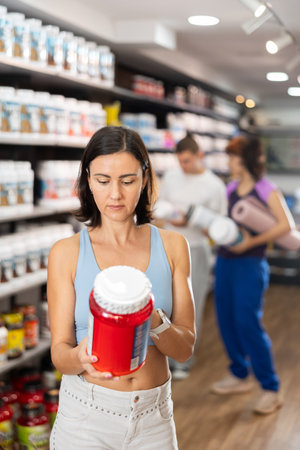 Woman chooses protein sports nutrition in storeの写真素材
