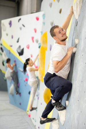 Young man practicing rock climbing on climbing wallの写真素材