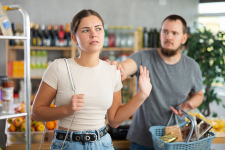 Husband calms his wife down after an argument in grocery supermarket, apologizingの写真素材
