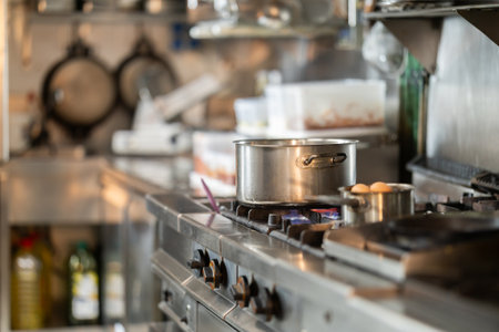Stovetop with stainless steel saucepans in restaurant kitchenの写真素材