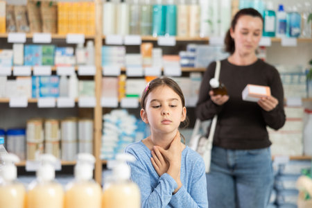 Woman chooses remedy for treating sore throat in childの写真素材