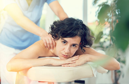 Portrait of young female which is lying on massage table in spaの写真素材