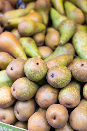 View of ripe pears in a wicker basket, put up for sale in store