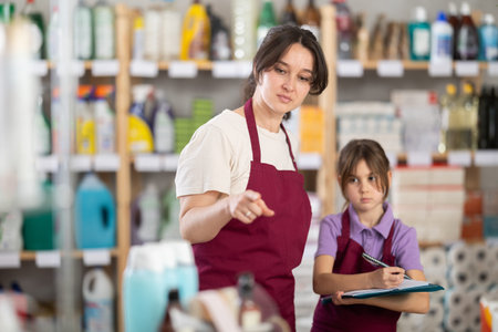 Woman seller and her daughter take inventory in store