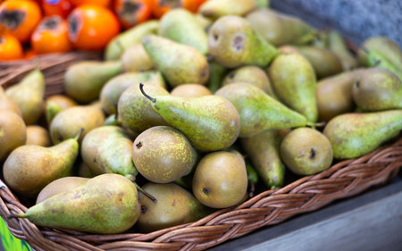 View of ripe pears in a wicker basket, put up for sale in storeの写真素材