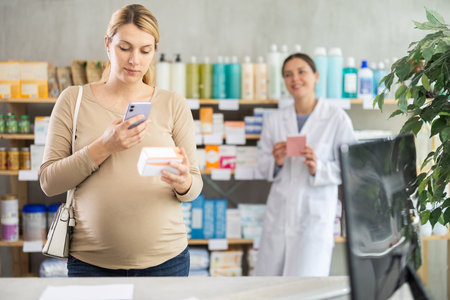 Pregnant woman scan QR code on vitamin pills product, pharmacist offer similar product in backgroundの写真素材