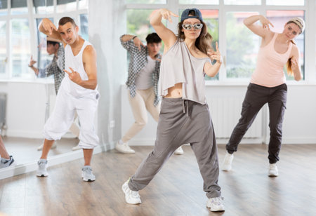 Active group sporty people practicing hip-hop dance in training hall during dancing classesの写真素材