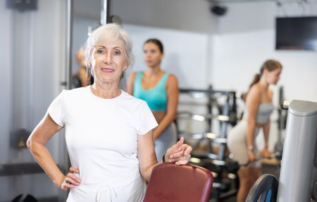 Elderly athletic woman posing in gymの写真素材