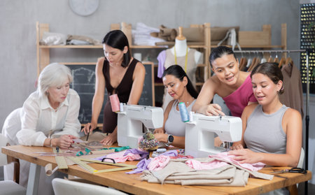 Group of busy women sewing and drawing with teacher at dressmaking coursesの写真素材
