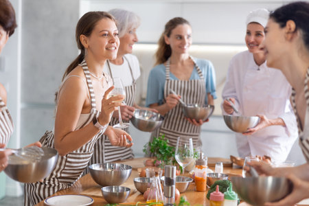 Young woman talks and drinks with group during master classの写真素材