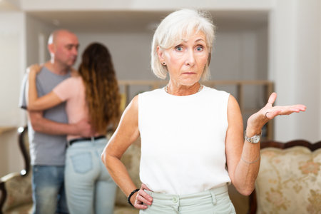 Domestic quarrel relatives in apartment. Adult offended woman turned awayの写真素材