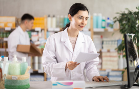 Woman pharmacist looking for prescription on computerの写真素材