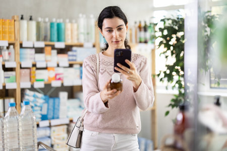 Woman scans the barcode of medicated syrup for coughの写真素材