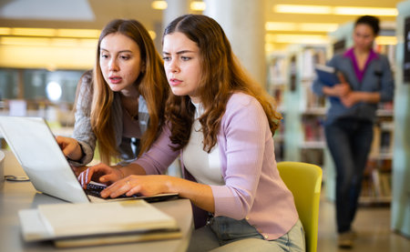 Portrait of two woman working in university library