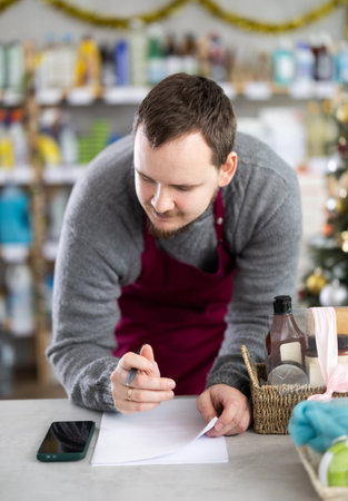 Owner of cleaning supplies store reviewing paperworks and using smartphoneの写真素材