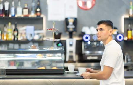 Guy drinking coffee in a cafeの写真素材