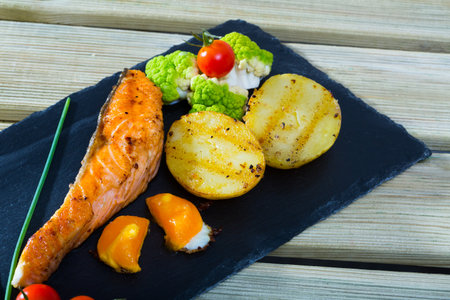 Grilled salmon with egg yolk and vegetablesの写真素材