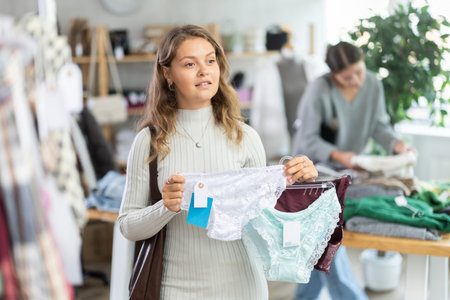 Young woman chooses panties in clothing storeの写真素材