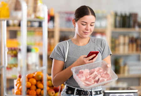 Woman scanning qr code of meat packagingの写真素材