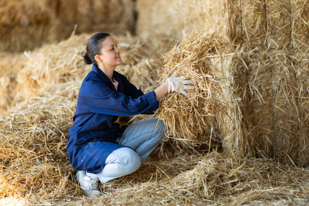 Asian female worker inspects straw in storageの写真素材