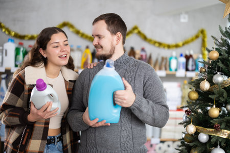 Happy man and woman looking for household liquid detergents on shelves in store.の写真素材