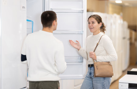 Young couple chooses modern fridge at hypermarketの写真素材