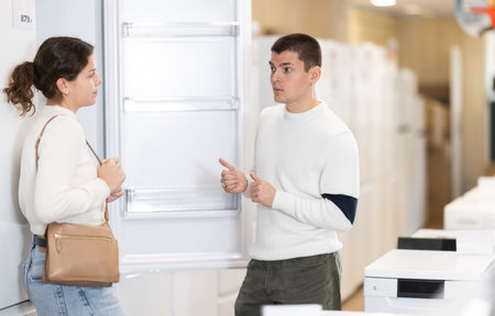 Young couple chooses modern fridge at hypermarketの写真素材