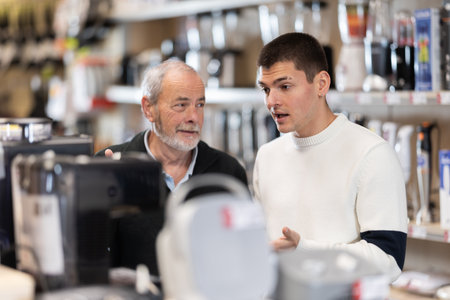 Eldery and young man choosing coffee machineの写真素材