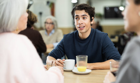 Happy young guy meeting and celebration with big friendly family over dinnerの写真素材