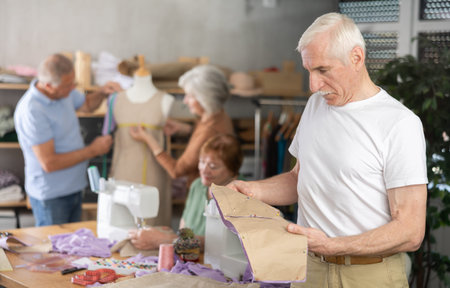 Elderly man with pattern at sewing master class