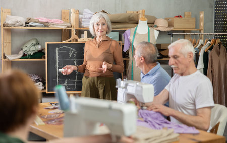 Elderly female teacher conducts master class on sewingの写真素材