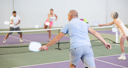 Rear view of man in sportswear playing pickleball tennis on court. Racket sport trainingの写真素材