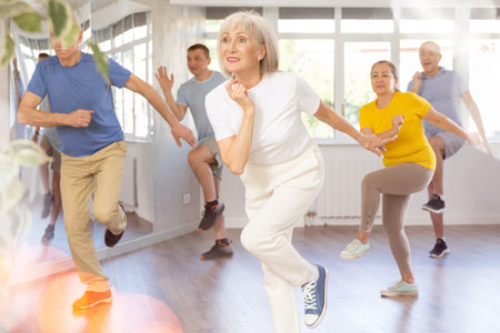 Group of aged people rehearsing sports dance in dance class
