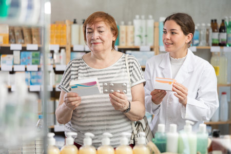 mature woman chooses paracetamol and consults a pharmacistの写真素材