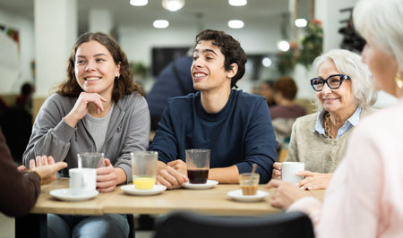 Large friendly family gathered at table to have meeting in restaurant