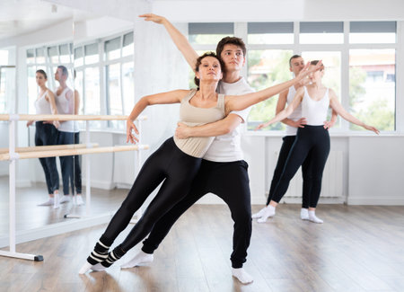 Amateur ballet partners mastering paired technique at group class