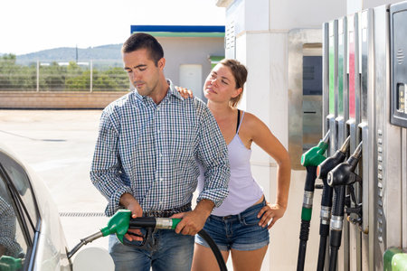 Couple refuelling their car at petrol filling stationの写真素材