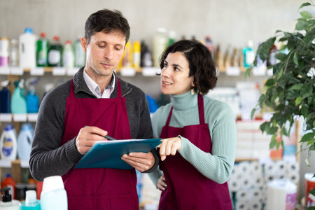 Two sellers make notes on a paper - conduct an inventory in a shopの写真素材